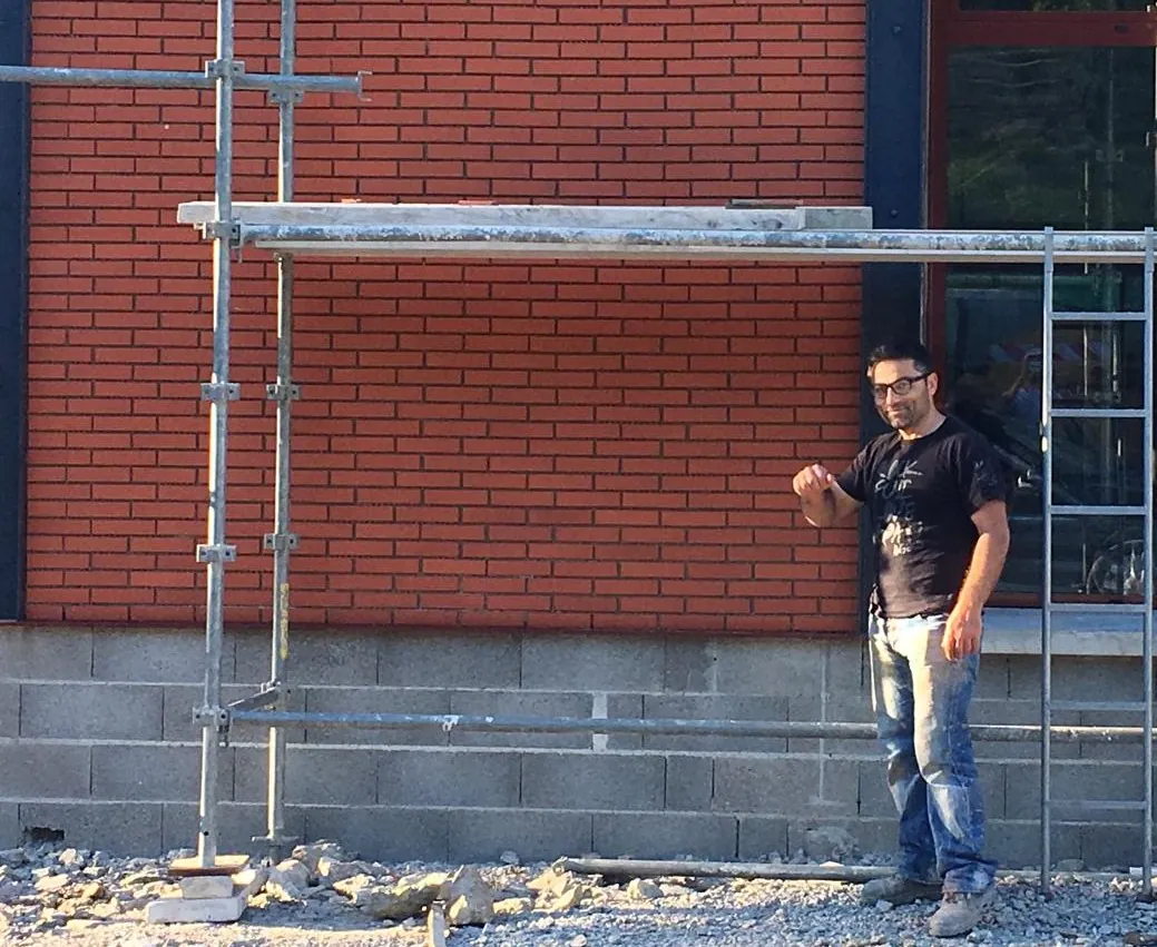 Le fondateur d'EcoBat36 devant une façade en brique en chantier